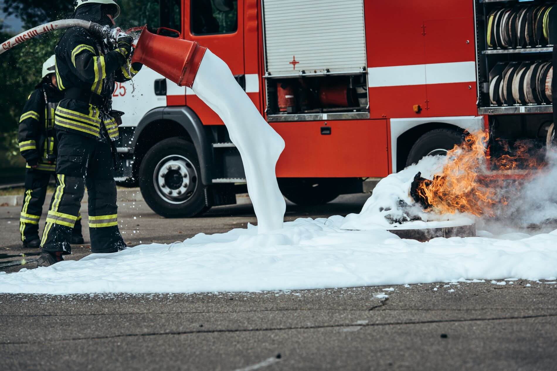 Fire fighter using suppressant foam on a fire. The foam can contain endocrine disrupting chemicals.