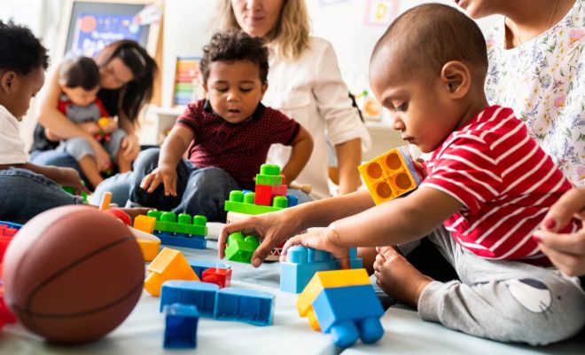 Children and parents playing with blocks and toys at school or daycare.