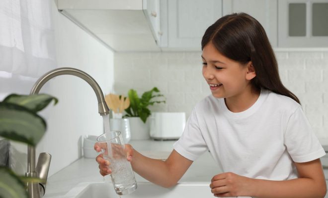 Child drinking water from the kitchen sink.