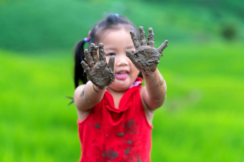 Kid playing with mud.