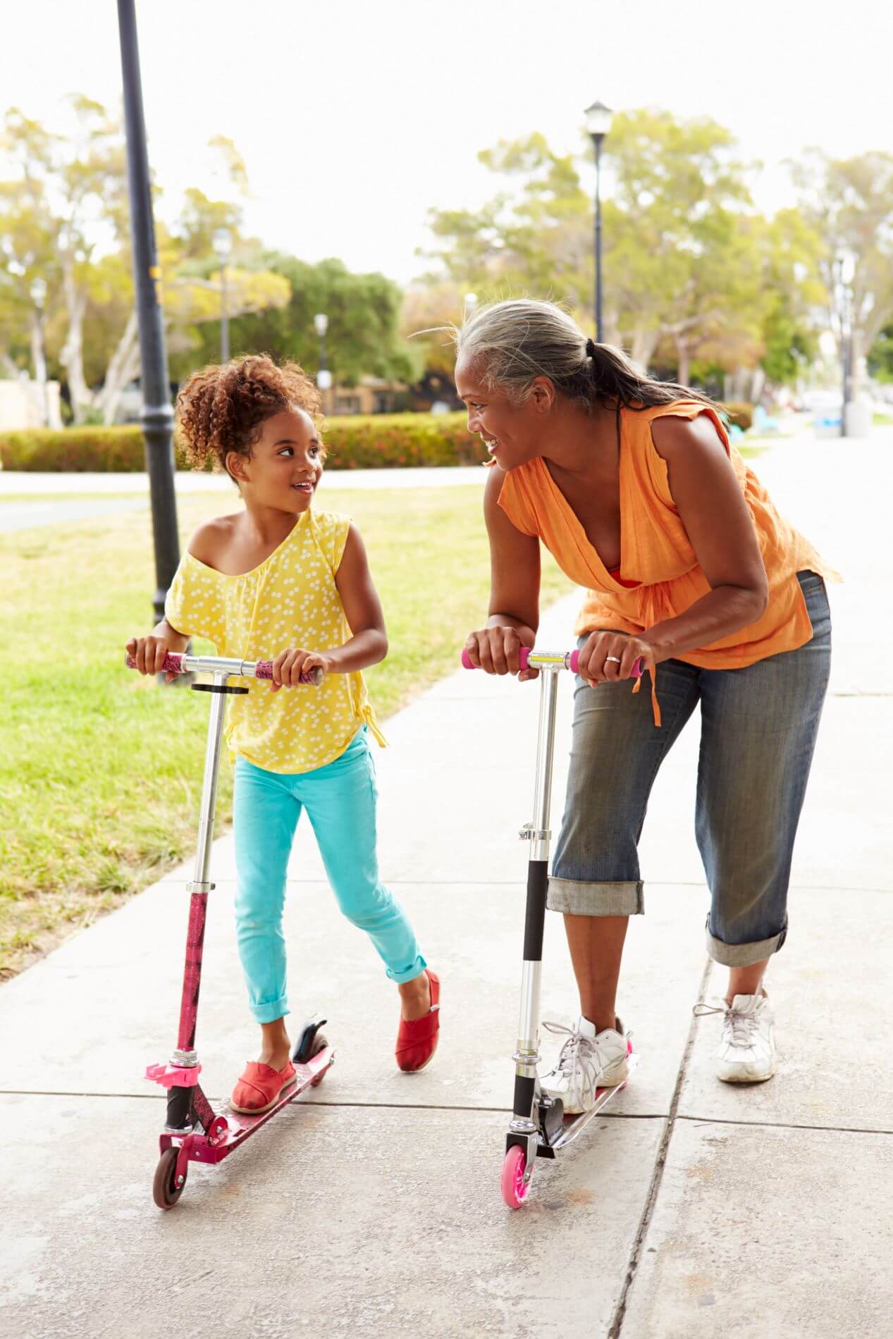 Child and grandparent using scooters.