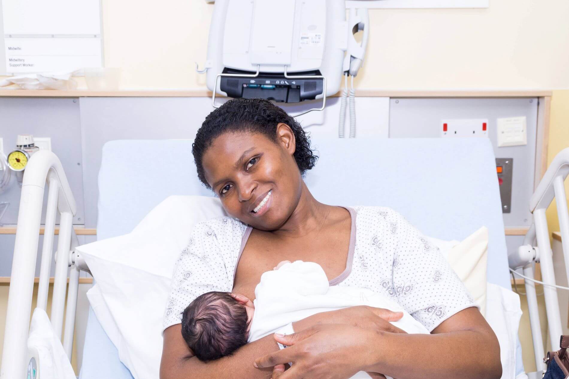 Woman who just gave birth with her infant in the hospital.