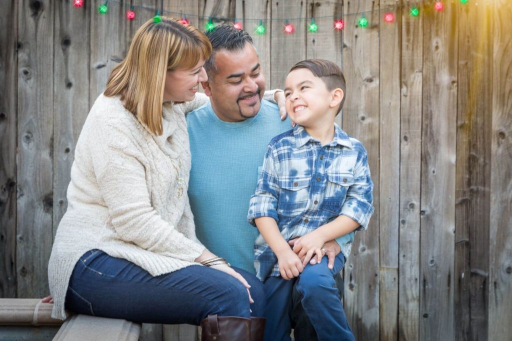 Family having fun outside under holiday lights.