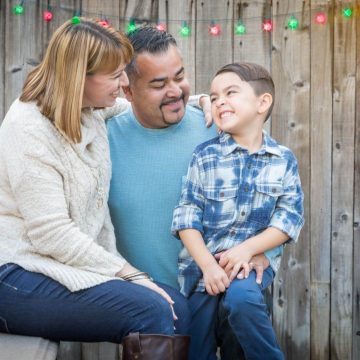 Family having fun outside under holiday lights.