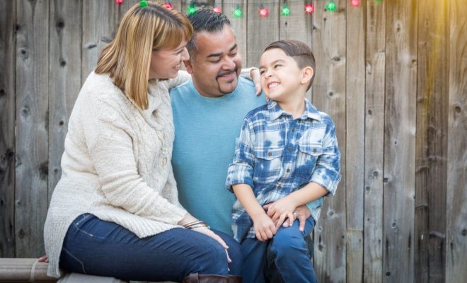 Family having fun outside under holiday lights.