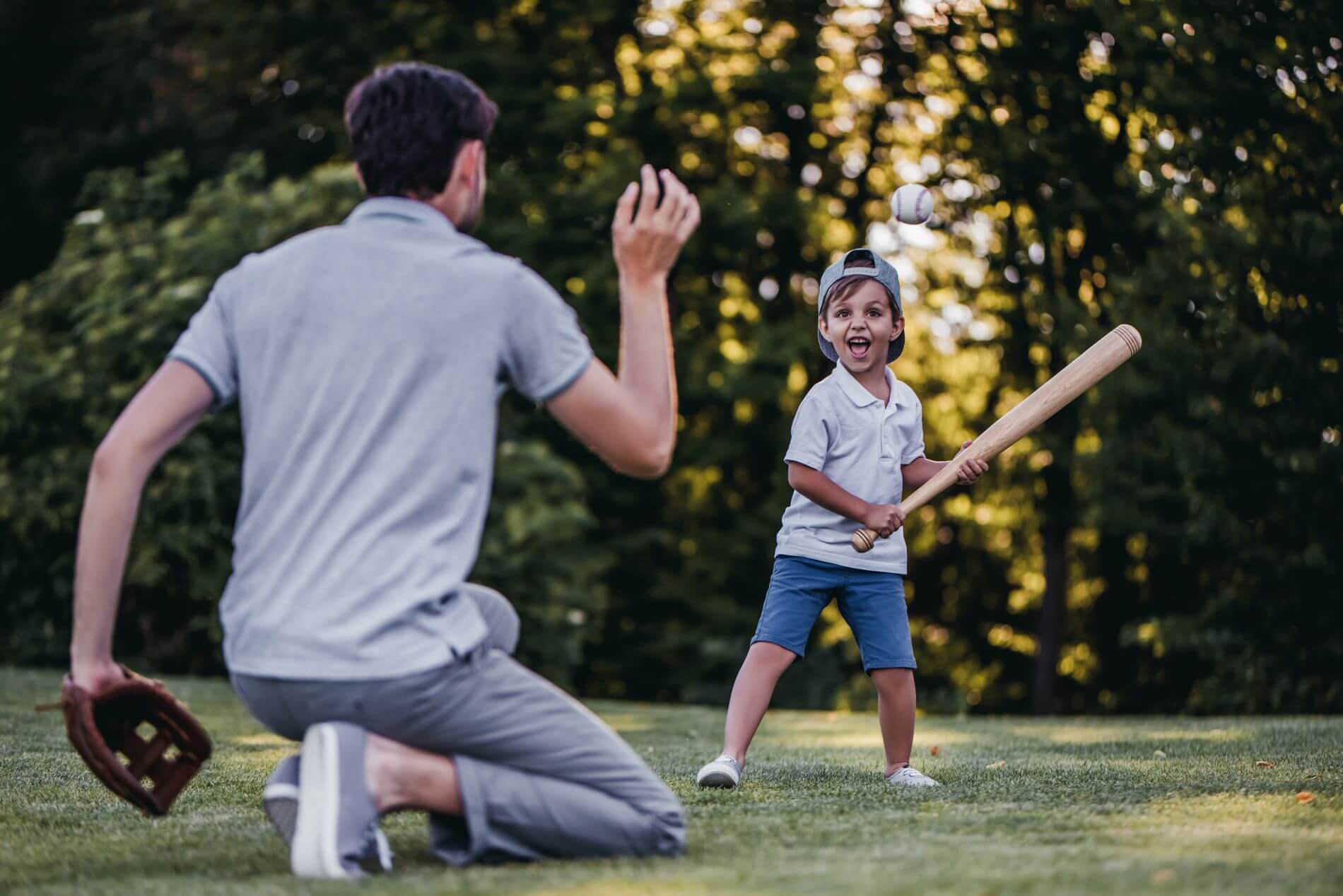 Child playing baseball with man.