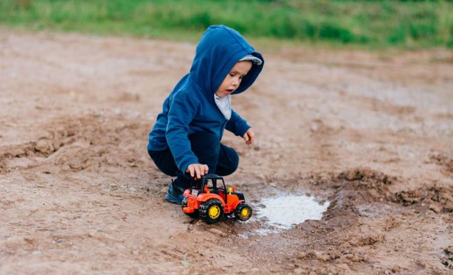 Baby playing with truck in the mud.