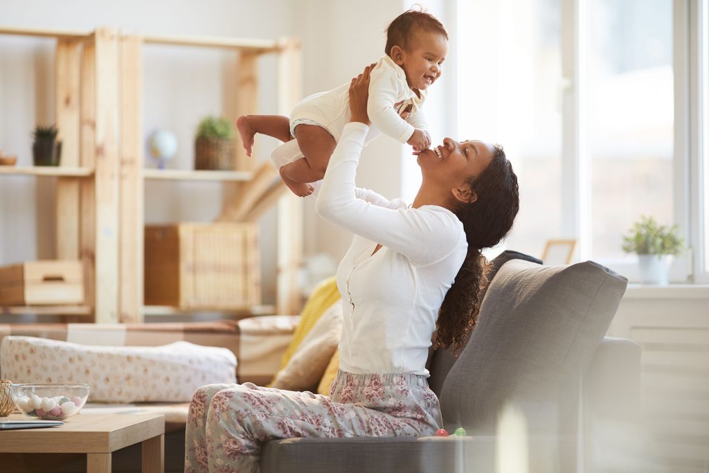 Mother playing with child in a living room.