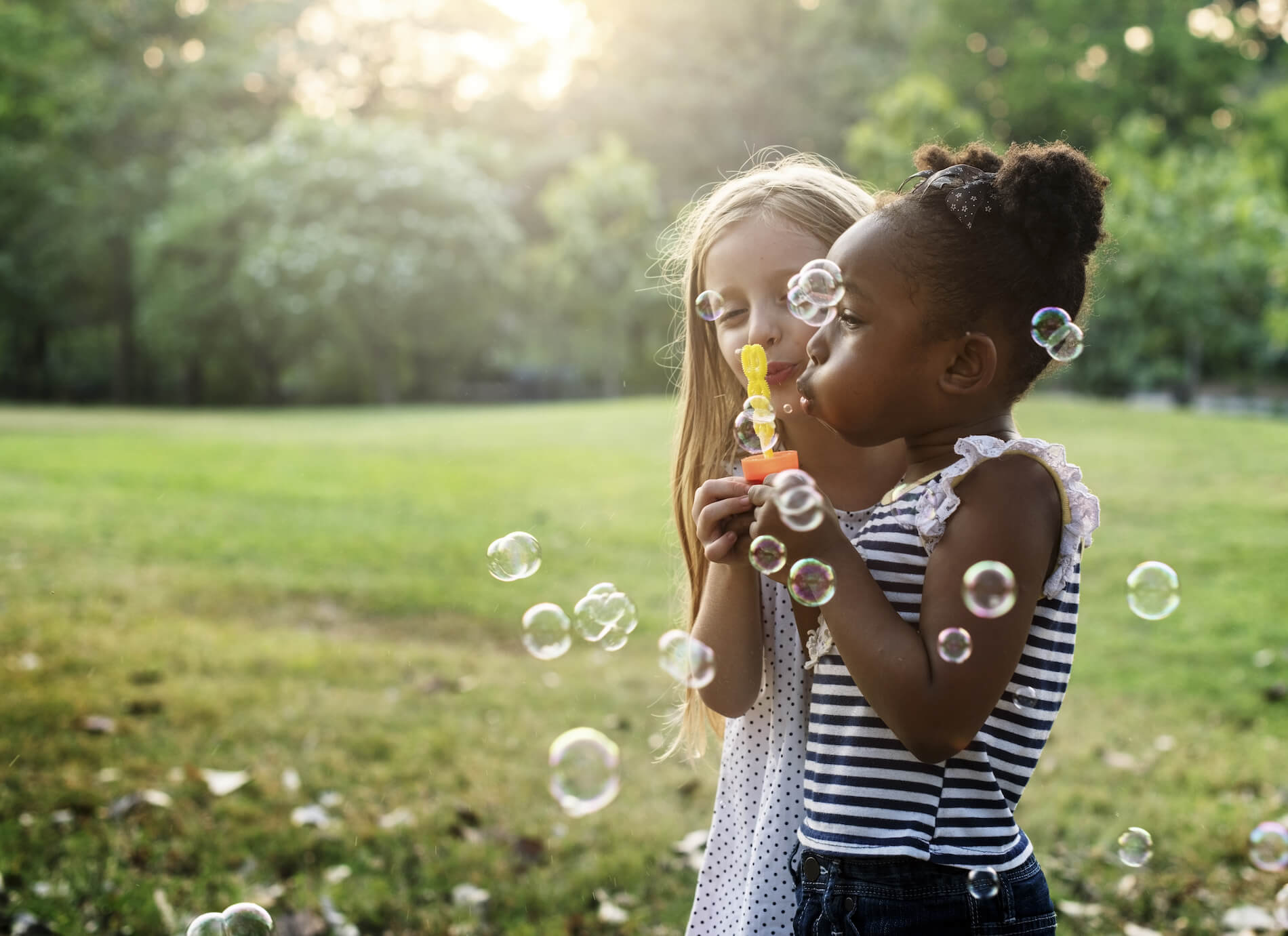 Two kids blowing bubbles.