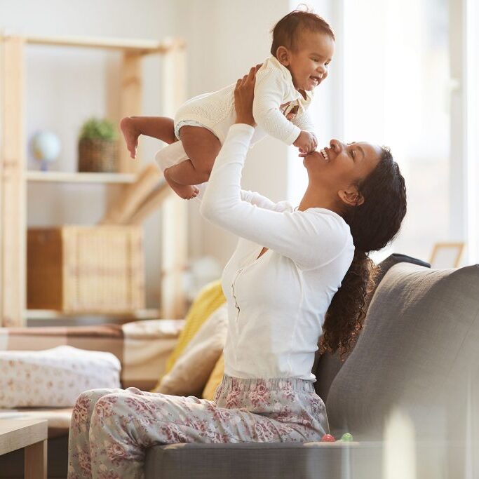 Mother playing with child in a living room.
