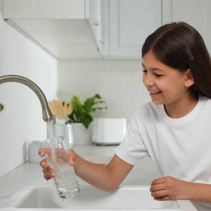 Child drinking water from the kitchen sink.