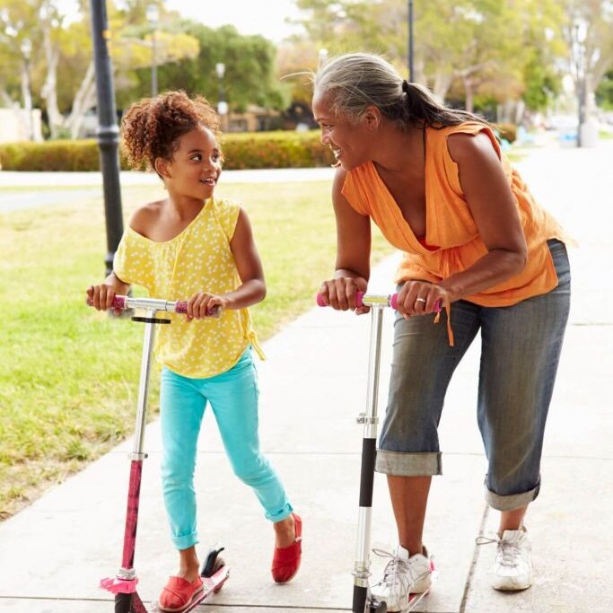 Child and grandparent using scooters.