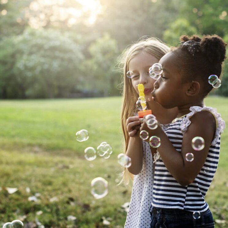 Two kids blowing bubbles.